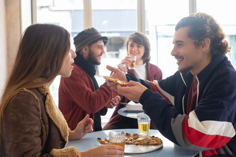 Happy customers eating pizza at a restaurant - customer reviews for restaurants